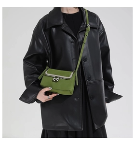 Gros plan du mini sac bandoulière vert avec fermoir argenté et texture en cuir