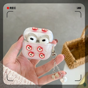 Detail der glitzernden AirPods-Hülle mit 3D-Apfel und Perlen-Schleifen-Anhänger
