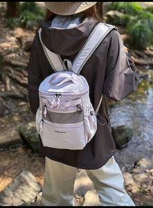 Vista esterna di uno zaino leggero in nylon lavanda con tasche multiple e rete laterale