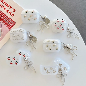 Glitzer Hülle für AirPods 4 mit Kirschmotiv und Schleifenanhänger auf weißem Tisch