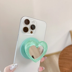 Detail of mint green heart-shaped phone grip with glitter finish and integrated makeup mirror