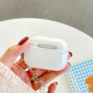 Detail of AirPods Pro case featuring a large pearl and bowknot keychain attachment