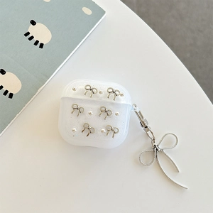 Close-up of translucent glitter AirPods case with silver metal bow and pearl accents