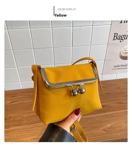 Detail of yellow lychee leather crossbody bag with vintage silver kiss-lock closure