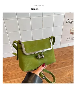 Detail of green litchi leather handbag with large silver metal ball clasp closure
