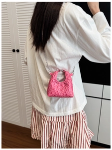Close-up of pink quilted mini bag with silver chain strap and metal ring handle for kids