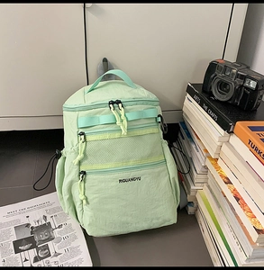 Dettaglio dello zaino in nylon verde menta con tasca a rete traspirante e cerniere sicure