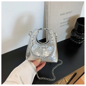 Detail of silver metallic mini bag with circular quilting and metal chain strap
