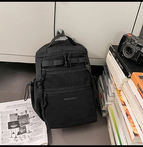 Dettaglio dello zaino multifunzionale in nylon nero con tasche in rete e chiusure a zip