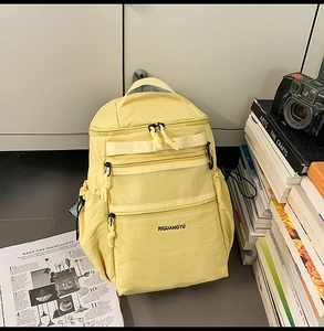 Dettaglio dello zaino in nylon giallo brillante con strato a rete e coulisse regolabili