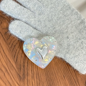 Détail du support de téléphone cœur irisé laser avec strass et centre en métal argenté