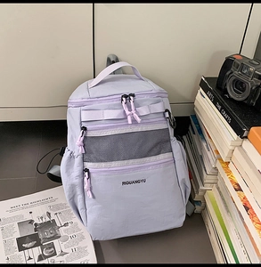 Dettaglio dello zaino in nylon viola chiaro con cerniere multistrato e tasche a rete