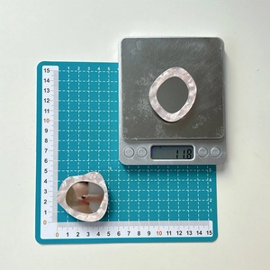 Macro shot of dolphin-shaped rhinestone mirror phone stand showing 11.8g weight on scale