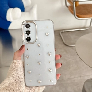 Detail of clear Samsung case with silver 3D hearts and pearls in a hand-held lifestyle shot