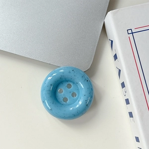 Vue détaillée du support de téléphone bouton bleu clair avec taches noires de style