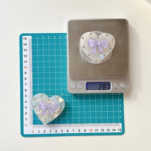 Detail view of pearlescent heart phone grip with rhinestones showing 55mm diameter size