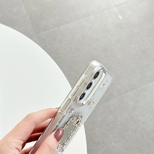 Detail of clear glitter phone case with silver camera ring and pink rhinestone ring holder