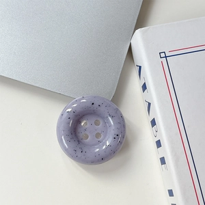 Gros plan du support de téléphone bouton lavande avec taches d'encre sur ordinateur