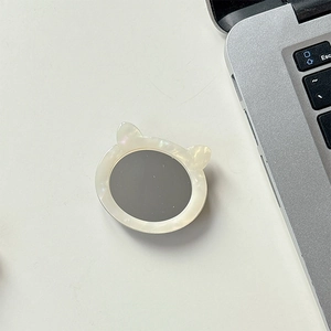Detail of a cat-ear phone socket with white pearlescent frame and grey mirror center