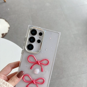 Detail of clear Samsung case with pink resin bows, glitter finish, and pearl accents
