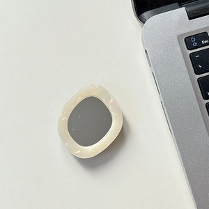 Detail showing the cream-colored rhinestone dolphin mirror phone socket on a desk