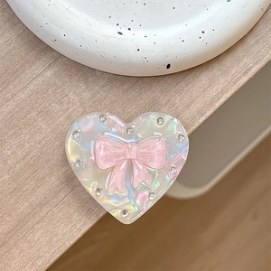 Macro shot of laser heart magnetic phone stand with pink bow and inlaid rhinestones
