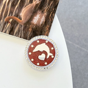 Macro shot of phone grip featuring a red glitter heart, dolphin design, and rhinestones
