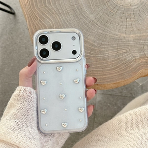 Close-up of heart-decorated cream phone case for iPhone 16 Pro Max on a wood base