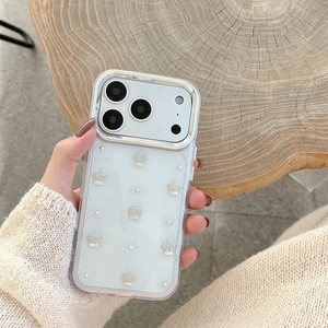 Close-up of clear iPhone case with silver crowns, pearls, and metallic lens protection