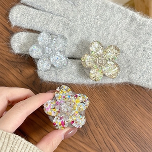 Detailed view of three 3D glitter flower phone grips on a wooden surface for phone decor