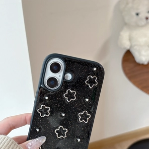 Close-up of glitter black phone case with silver metal flower charms for iPhone