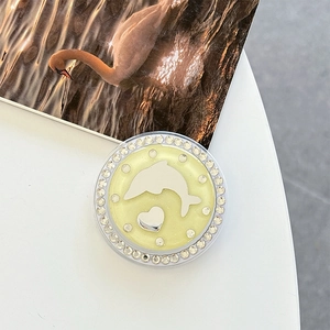 Detailed view of a round phone grip featuring a silver dolphin heart and rhinestones
