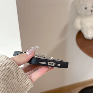 Detail of black matte phone case with silver metal studs and precise cutouts