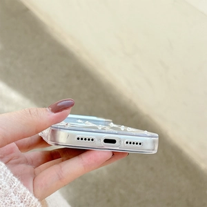 Detail of clear iPhone case with pearl bow accents and precise bottom charging port cutouts