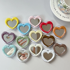 Close-up of heart-shaped magnetic mirror phone stands in assorted macaron colors