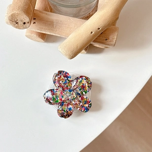 Macro detail of 3D resin flower phone grip with colorful sparkling glitter sequins