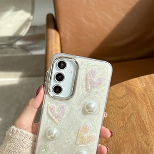 Detailed view of pearlescent Samsung phone case with 3D hearts, pearls, and glitter finish