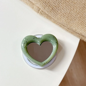 Detail of heart-shaped magnetic phone socket with mirror and green ink splash finish