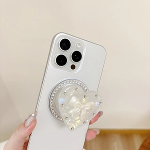 Support de téléphone cœur irisé avec nœud 3D et strass brillants tenu par la main