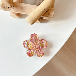 Detailed macro view of 3D cherry blossom phone grip with pink glitter and gold sequins