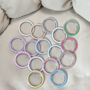 Colorful glittery circular phone grip bases in pastel candy colors on soft fabric