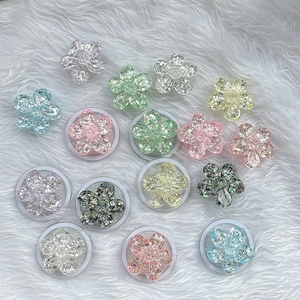 Supporto per cellulare a forma di fiore glitterato in vari colori su sfondo di pelliccia