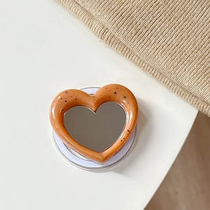 Macro shot of heart-shaped magnetic phone grip with mirror and tortoiseshell pattern