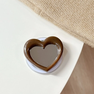 Detail of a heart-shaped magnetic phone holder with a makeup mirror and coffee-colored frame