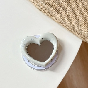 Detail of heart-shaped MagSafe phone grip with marble pattern and built-in mirror