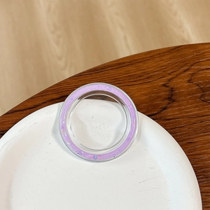 Close-up of a round phone socket stand with dreamy purple glitter on a ceramic plate