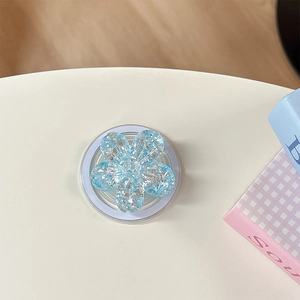 Dettaglio di un supporto per telefono a fiore blu con paillettes luccicanti