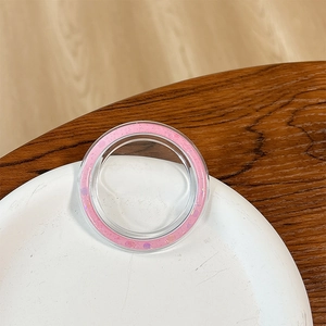 Detail of round phone grip base featuring pink glitter and sequins on a ceramic plate