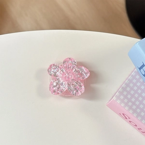 Dettaglio macro di un supporto per telefono a fiore rosa glitterato in resina