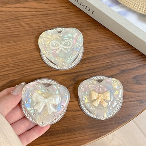 Support de téléphone en forme de cœur avec strass et nœud nacré sur bois naturel